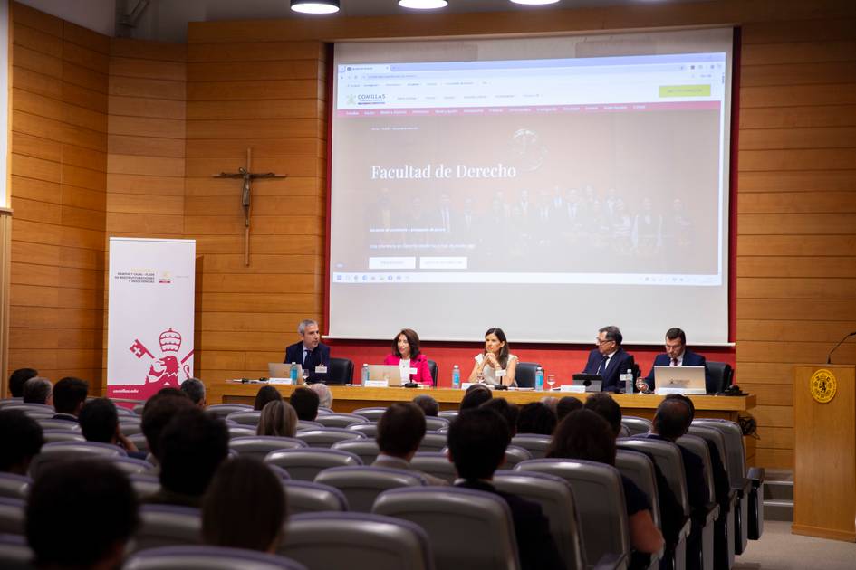 Una mesa redonda en la Facultad de Derecho con varios ponentes y asistentes en un auditorio.