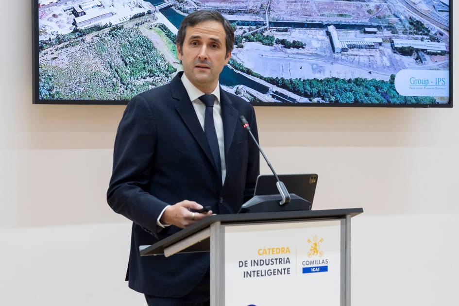 Un hombre de pie presenta información mientras se proyecta una imagen en una pantalla detrás de él.