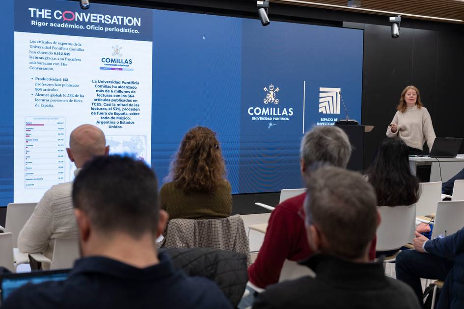 Una presentadora expone un tema frente a una audiencia en un evento organizado por la Universidad Pontificia Comillas.