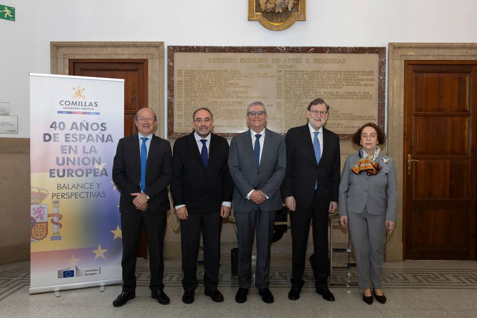 Un grupo de cinco personas posan en un evento con un banner sobre los 40 años de España en la Unión Europea.