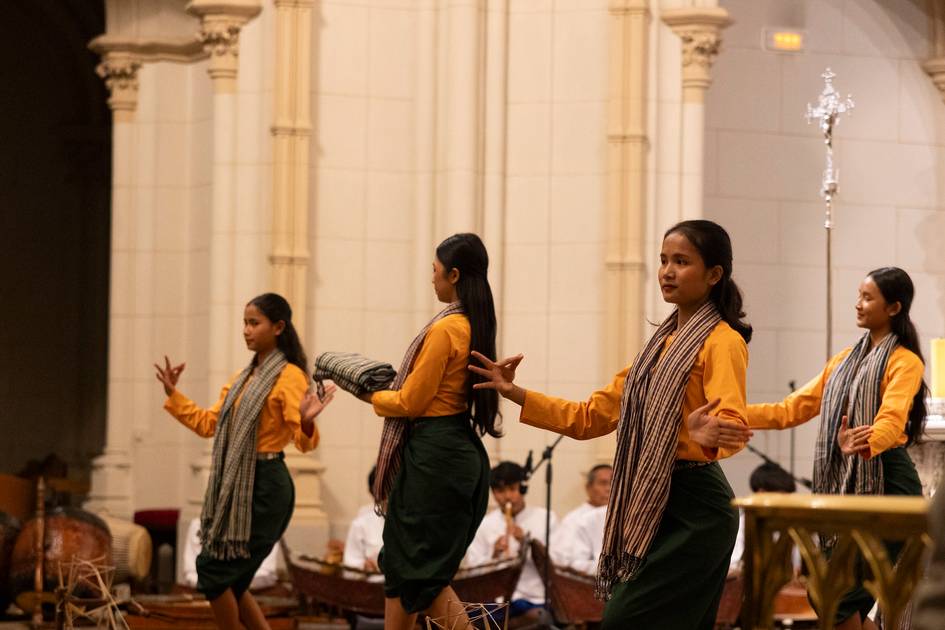 Un grupo de bailarinas se presenta en un escenario con trajes tradicionales durante un evento cultural.
