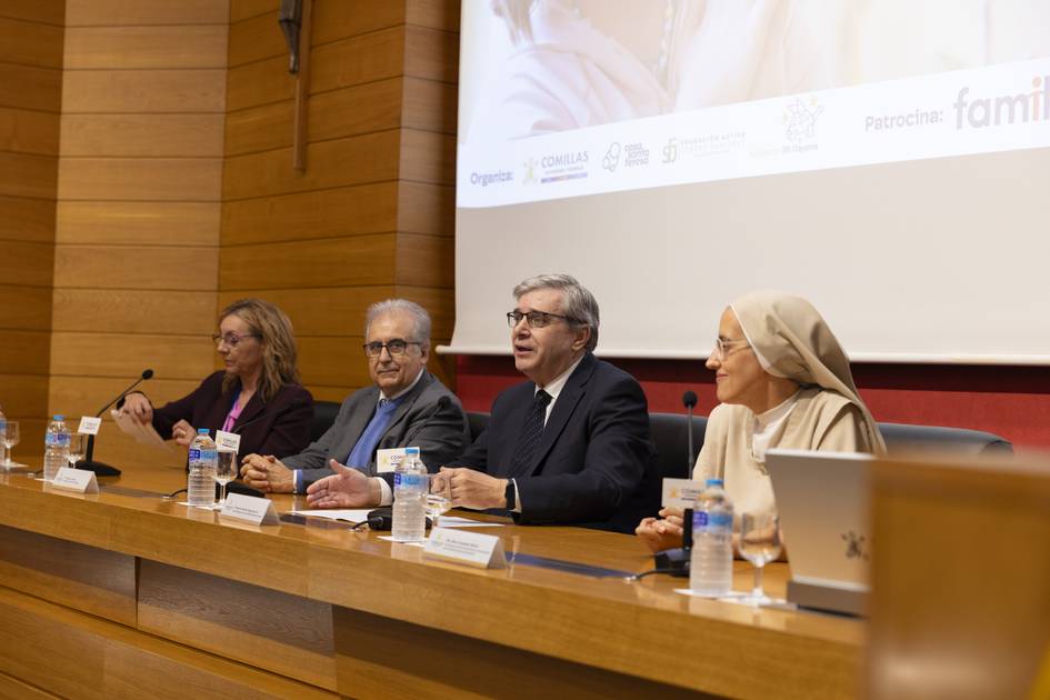 Una mesa de conferencia con cuatro ponentes sentados ante un público en un ambiente formal.