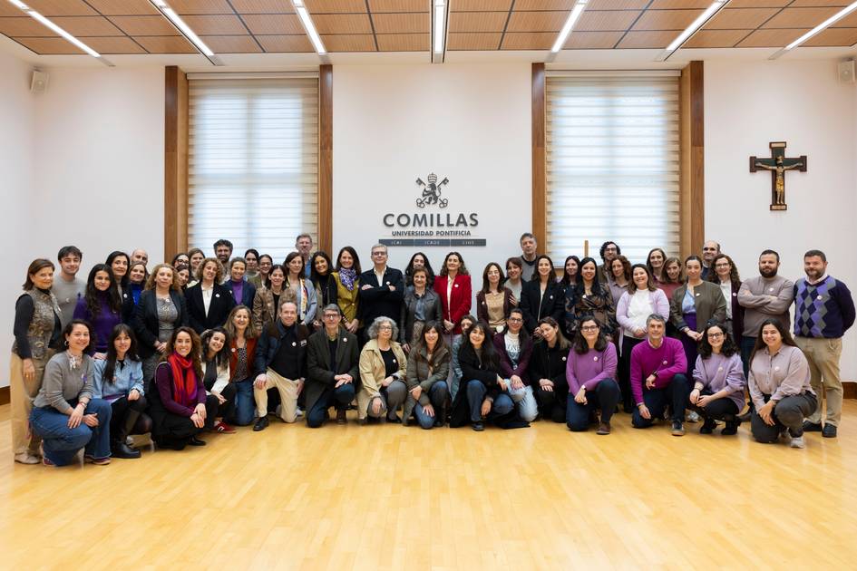 Un grupo de personas se reúne en un salón con un fondo que dice 'COMILLAS'.