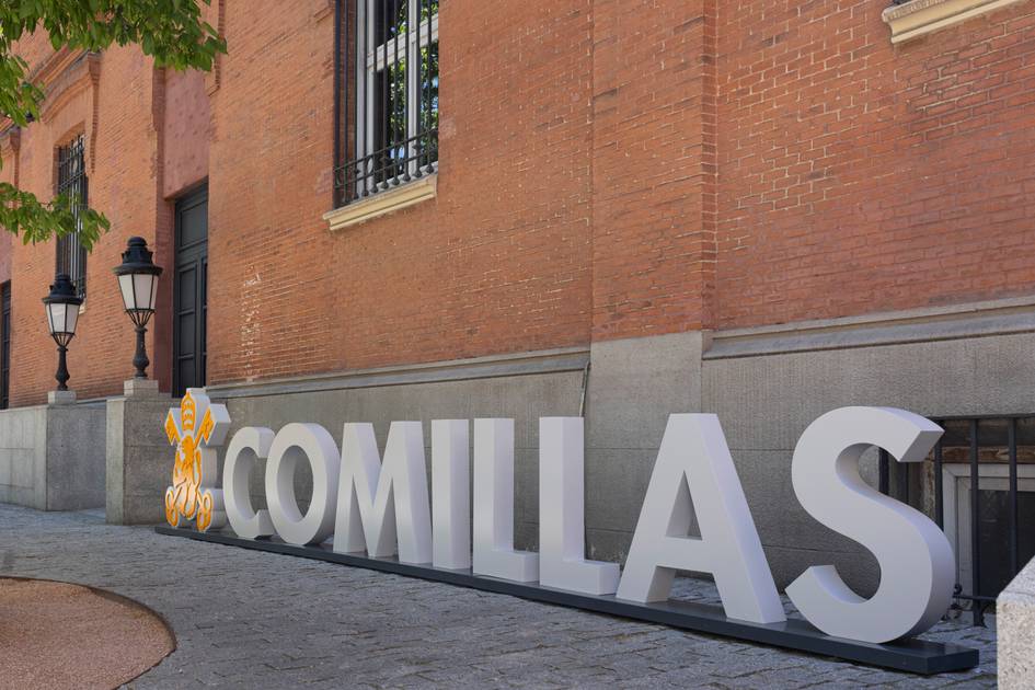 Fotografía del letrero que dice 'COMILLAS' en el exterior de un edificio de ladrillo.