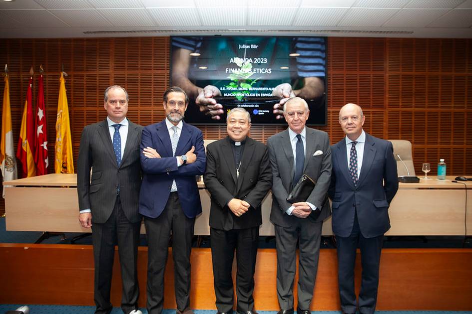 Five men standing in front of a presentation screen displaying financial information for the year 2023.