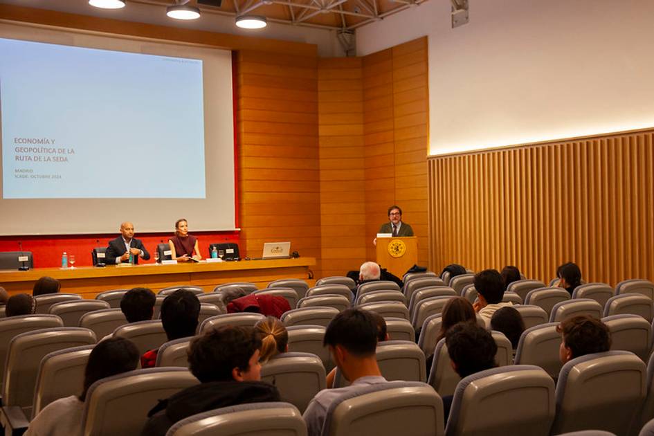 Conferencia en un auditorio con asistentes escuchando a un orador que está de pie frente a un podio.