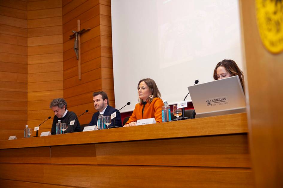 Cuatro profesionales sentados en un panel dentro de una sala de conferencias, participando en un evento académico.