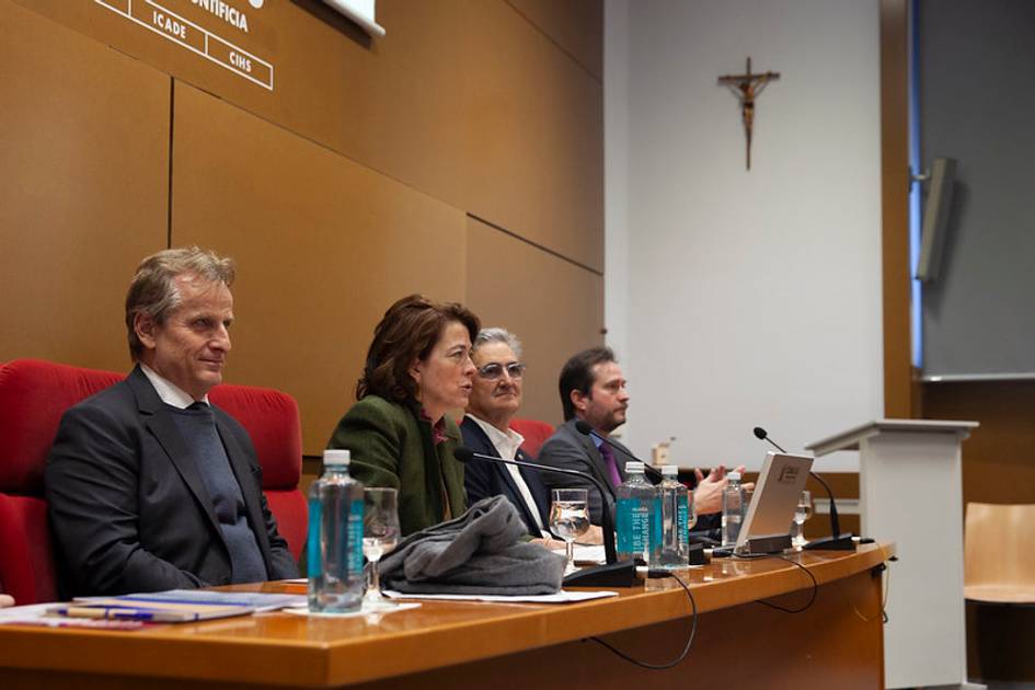 Una mesa redonda con cuatro ponentes en un entorno académico.