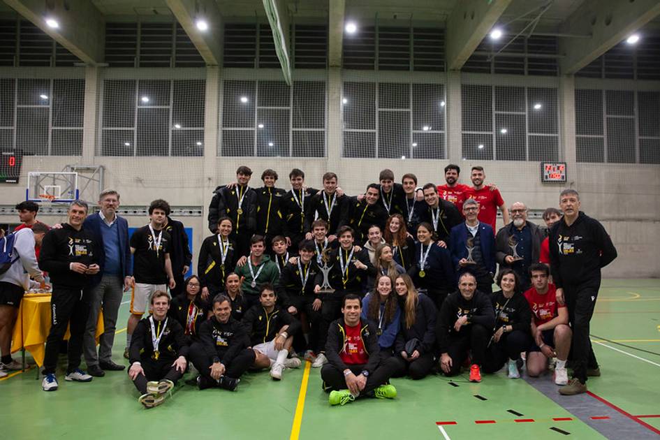 Grupo de personas posando en una cancha deportiva tras un evento deportivo con medallas.