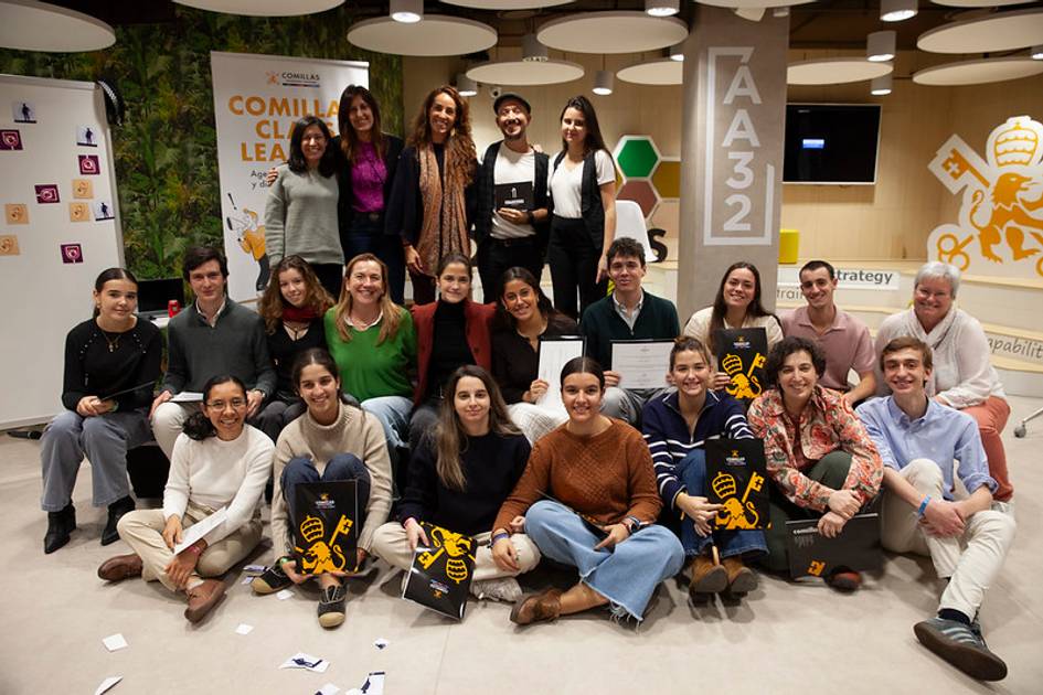 Un grupo de personas sonríe y posa en una sala de trabajo tras una actividad grupal.