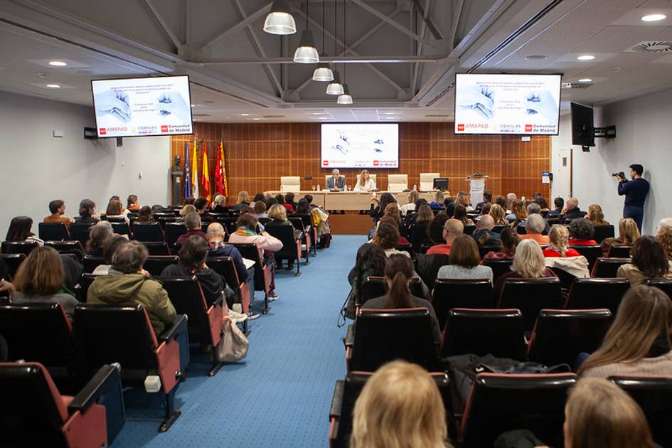 Una conferencia con un gran público en un auditorio, donde se presentan informaciones en pantallas.