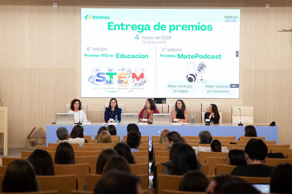Una ceremonia de entrega de premios en la que participan varias mujeres de pie detrás de una mesa y una audiencia atenta.