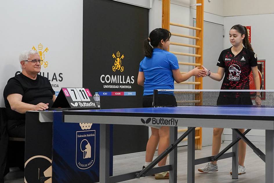 Dos jugadoras de tenis de mesa se saludan después de un partido en una competición.