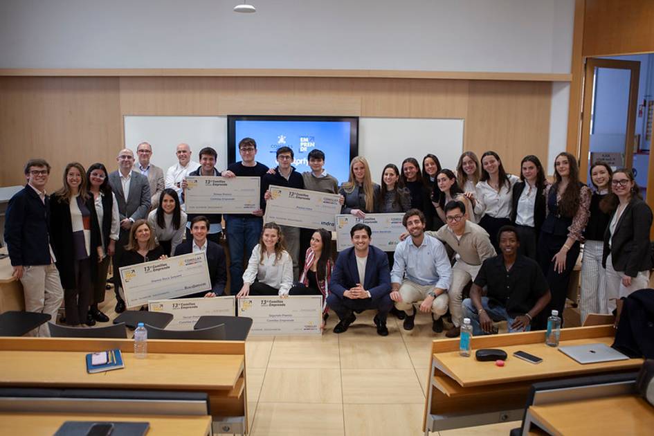 Un grupo de personas sonrientes posando en una sala con grandes cheques en manos, celebrando un logro.