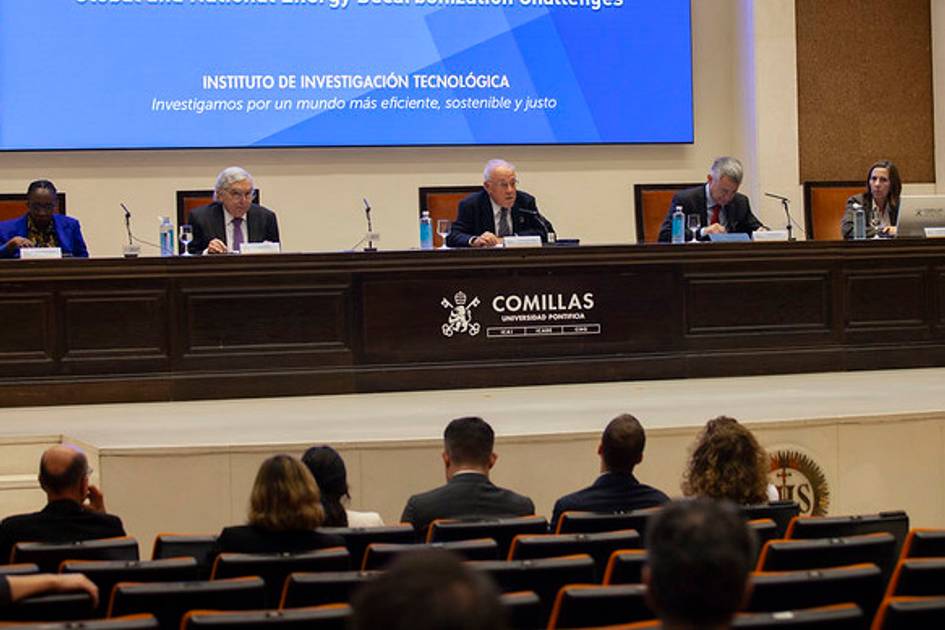 Un grupo de personas en un panel de discusión en un auditorio con un fondo que muestra un letrero del Instituto de Investigación Tecnológica de la Universidad Pontificia Comillas.