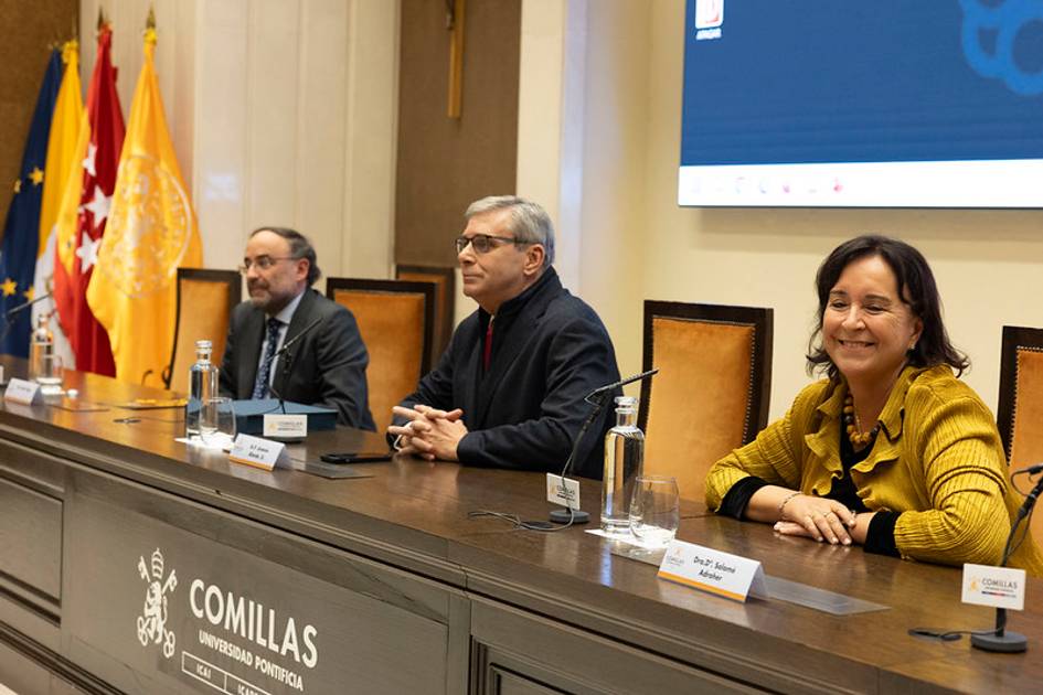 Un evento académico en la Universidad Pontificia Comillas con tres ponentes en el estrado.
