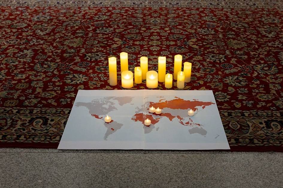 Un mapa del mundo iluminado con velas en una alfombra decorativa.