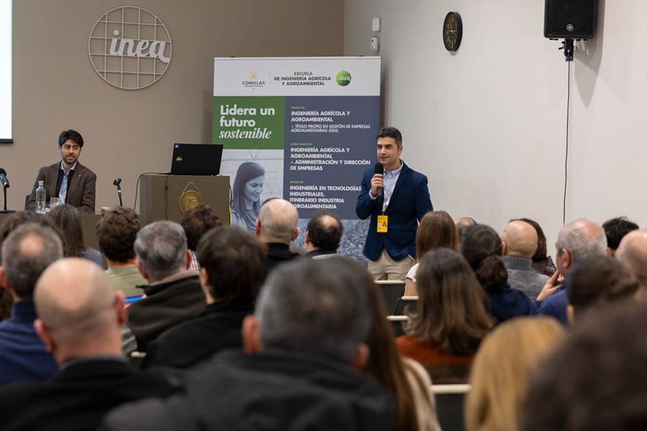 Una presentación en un evento sobre sostenibilidad con un orador hablando frente a una audiencia.