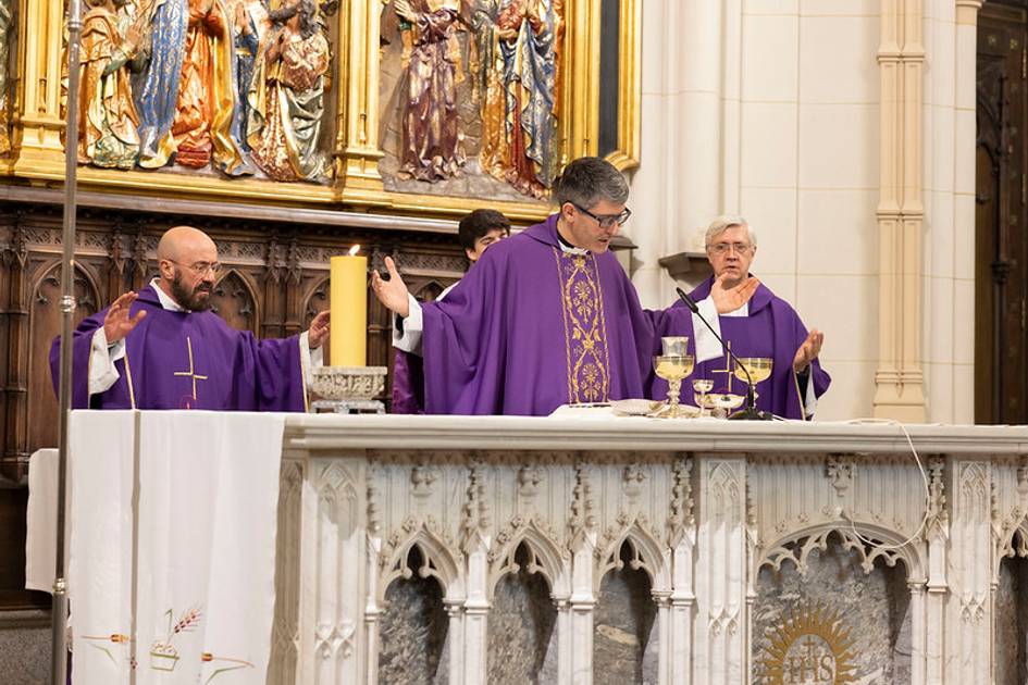 Celebración de una misa con tres personas en la mesa del altar.