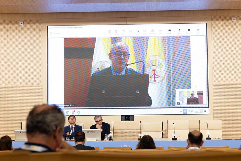 Un hombre habla en una conferencia mientras se proyecta su imagen en una pantalla grande.
