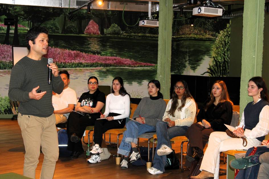 Un hombre habla en público ante un grupo de personas sentadas que lo escuchan atentamente.