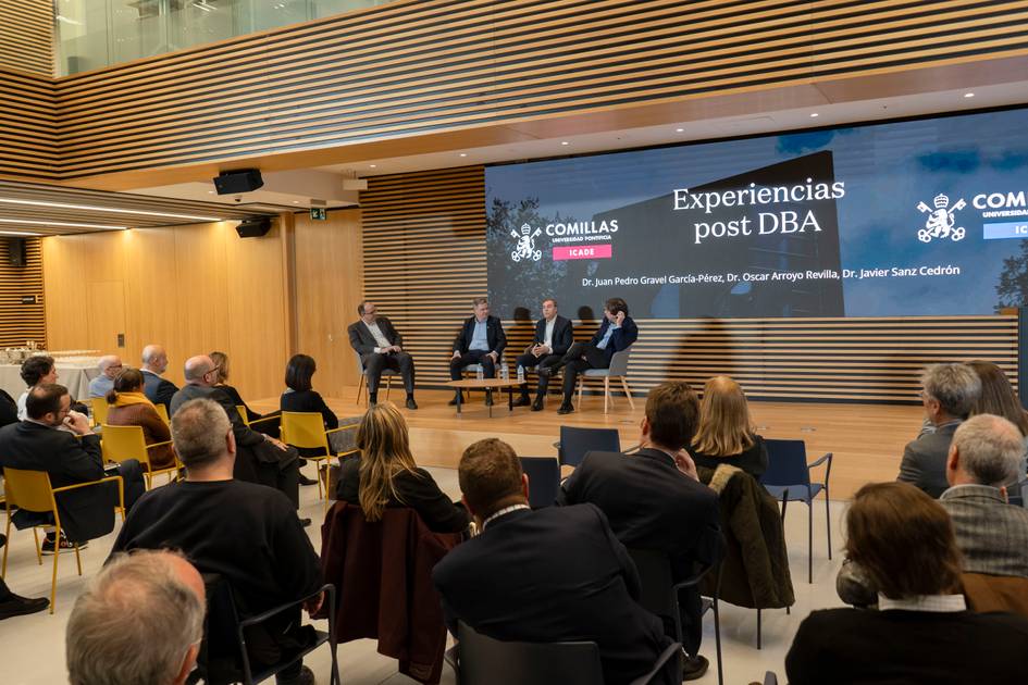 Un panel de discusión sobre experiencias post DBA en un auditorio moderno con asistentes en la audiencia.