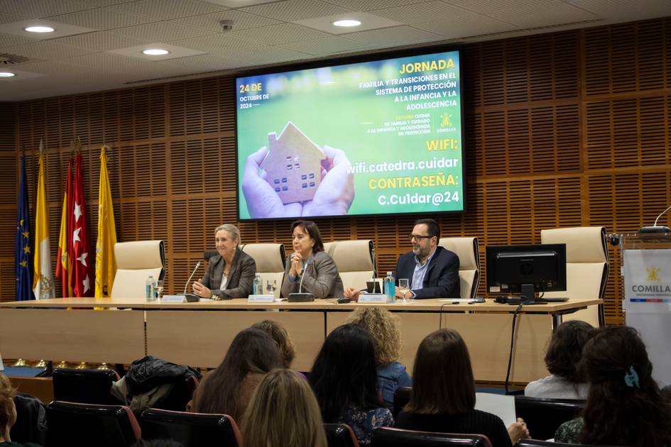 Three people sitting on a panel at a conference room during a professional event.