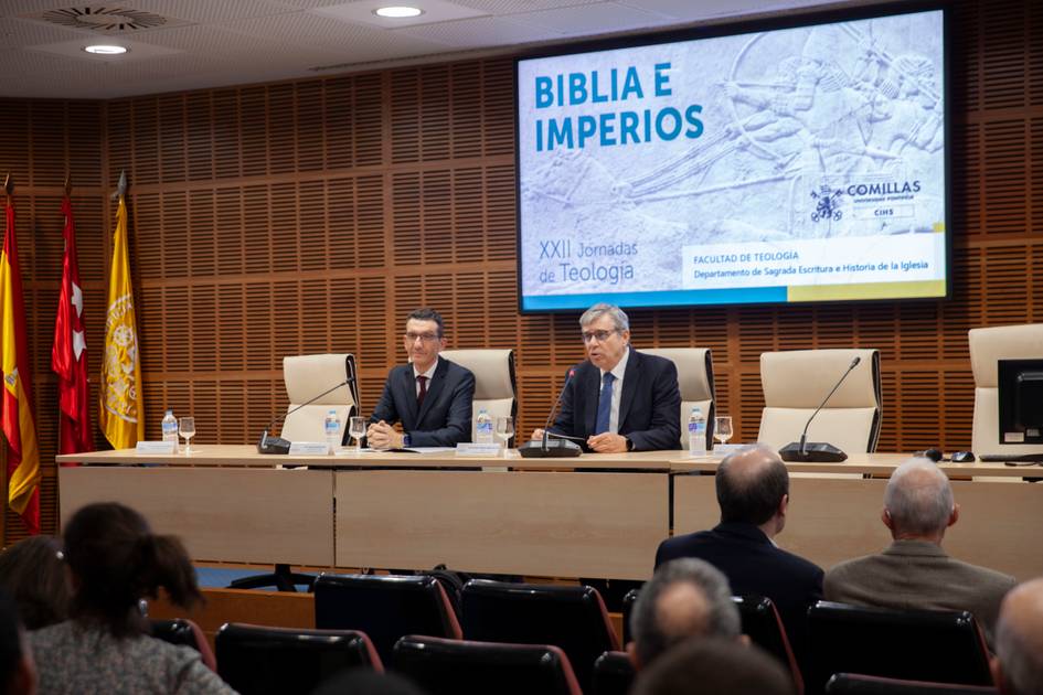 Dos ponentes discuten sobre el tema 'Biblia e Imperios' durante una jornada de teología en una sala de conferencias.