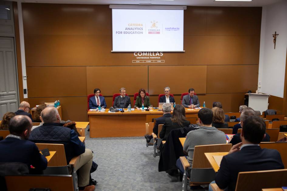 Una mesa redonda sobre análisis de datos en la educación con varios ponentes y asistentes en un auditorio.