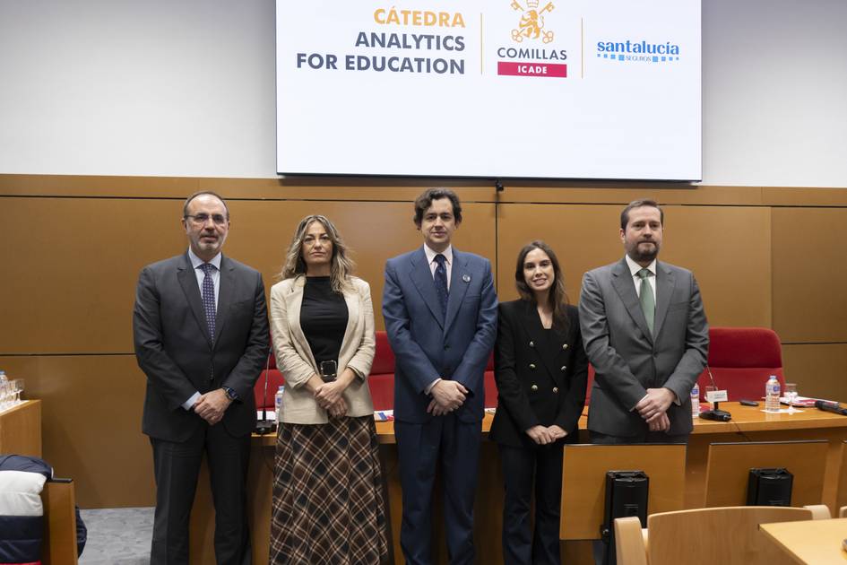 Un grupo de personas posando frente a una pantalla que muestra un logotipo académico.