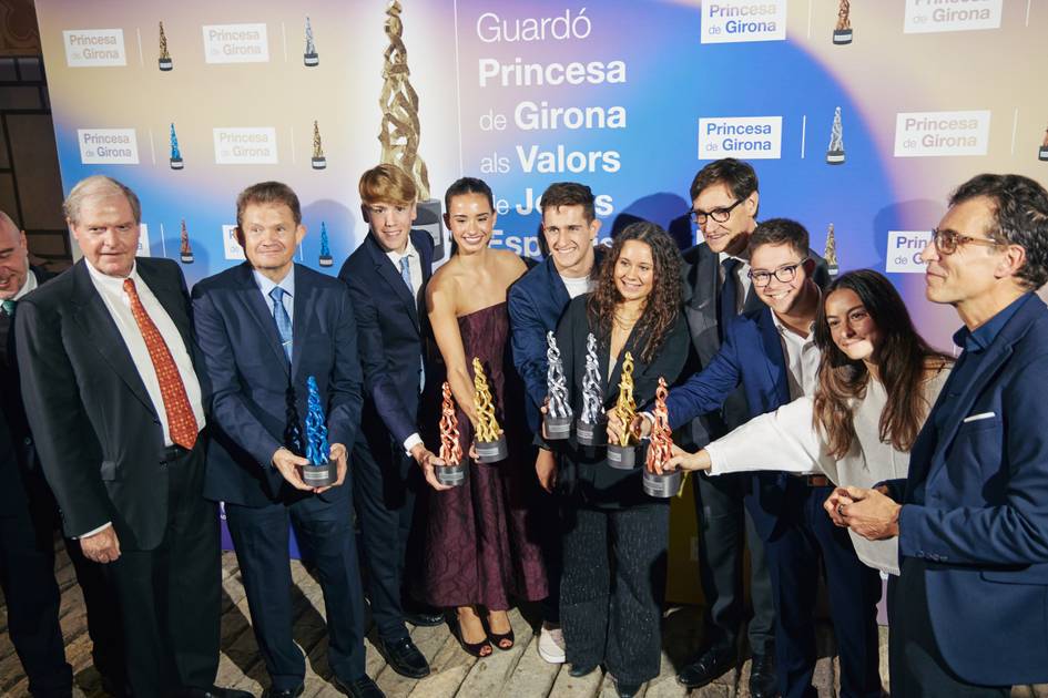 Un grupo de personas sonríe mientras sostiene premios en un evento de entrega de galardones.