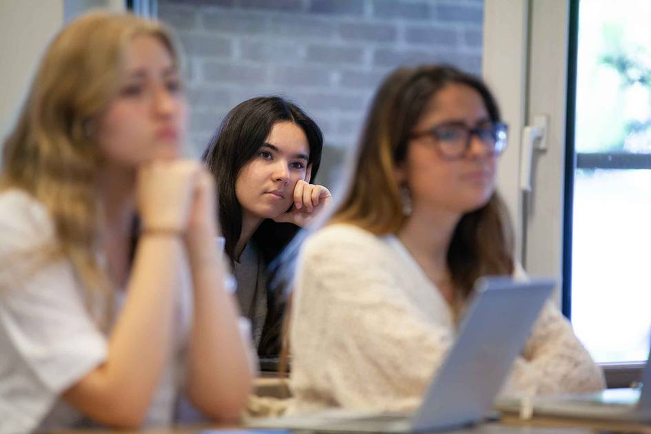 Un grupo de estudiantes escucha atentamente en un aula.