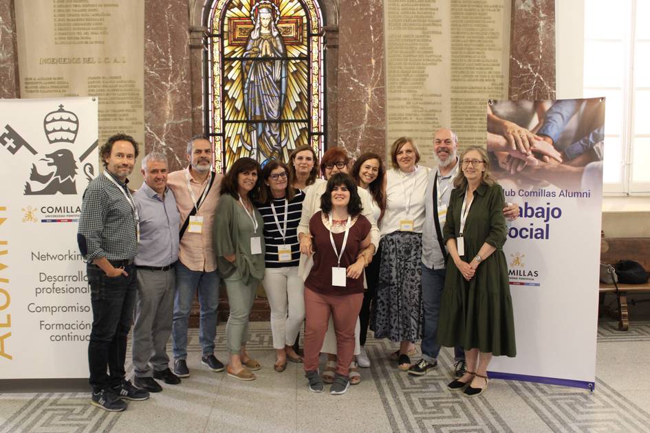 A group of people posing for a photo in front of a stained glass window at a social work event.