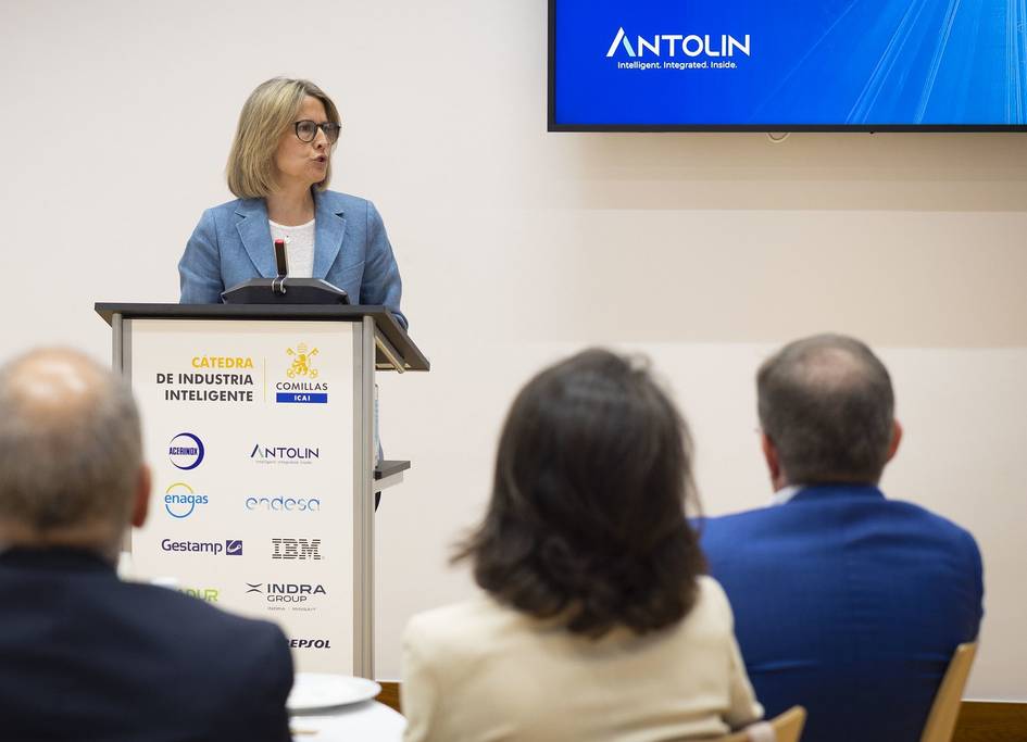 Una mujer presenta un discurso en un evento sobre industria inteligente.