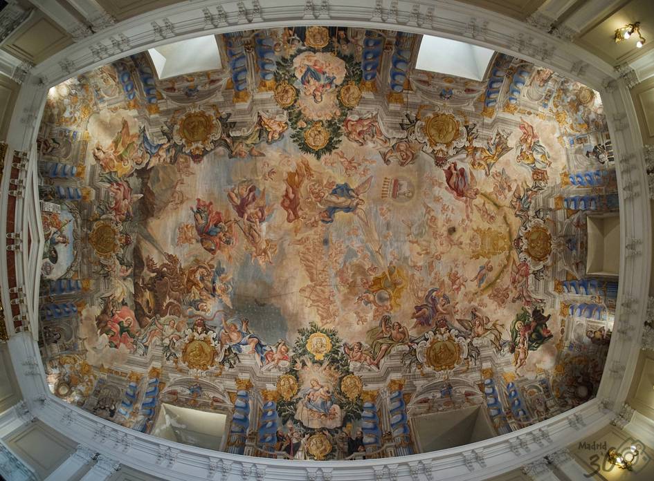 El techo de una sala adornado con frescos elaborados que representan escenas mitológicas y figuras alegóricas.