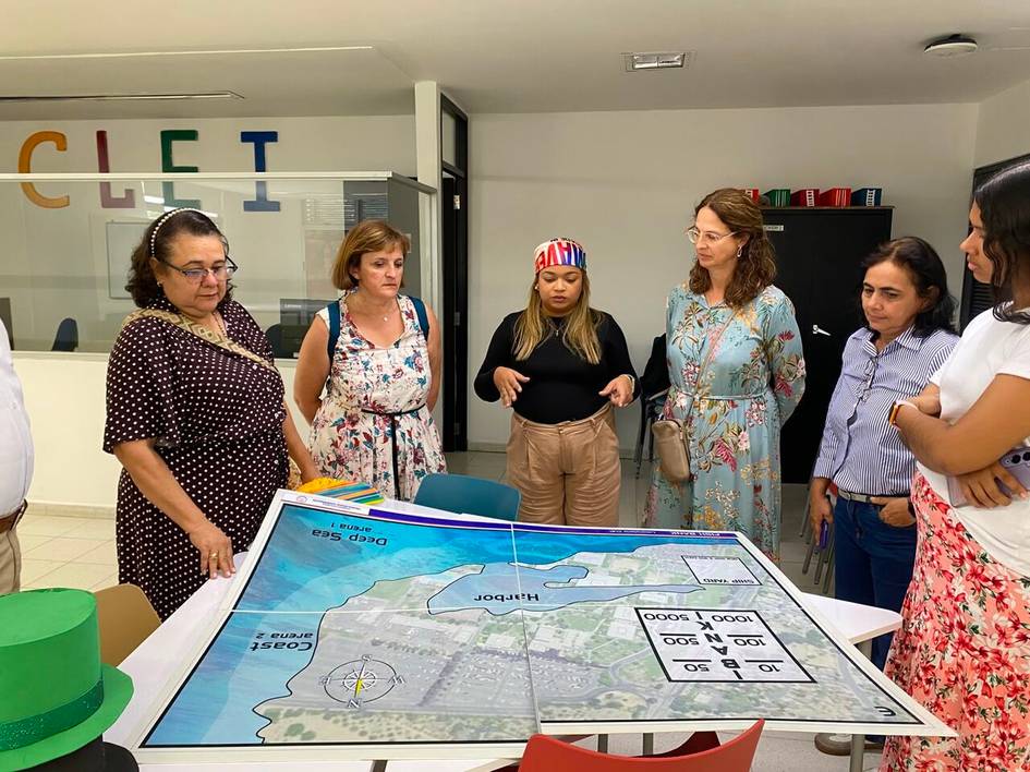 Un grupo de mujeres está observando y discutiendo sobre un mapa en una sala de reuniones.