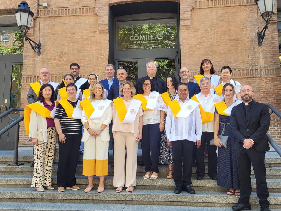 A group of people in academic attire standing in front of the Comillas building.