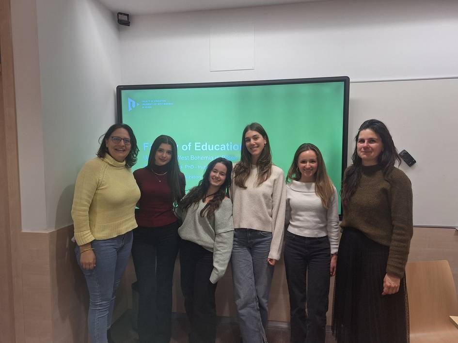 Un grupo de seis mujeres posando frente a una pantalla con un fondo verde.