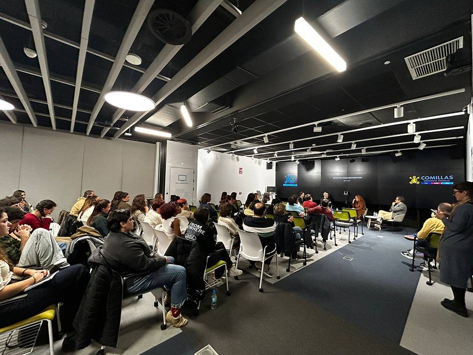Una sala de conferencias con un gran grupo de personas sentadas escuchando a un ponente.