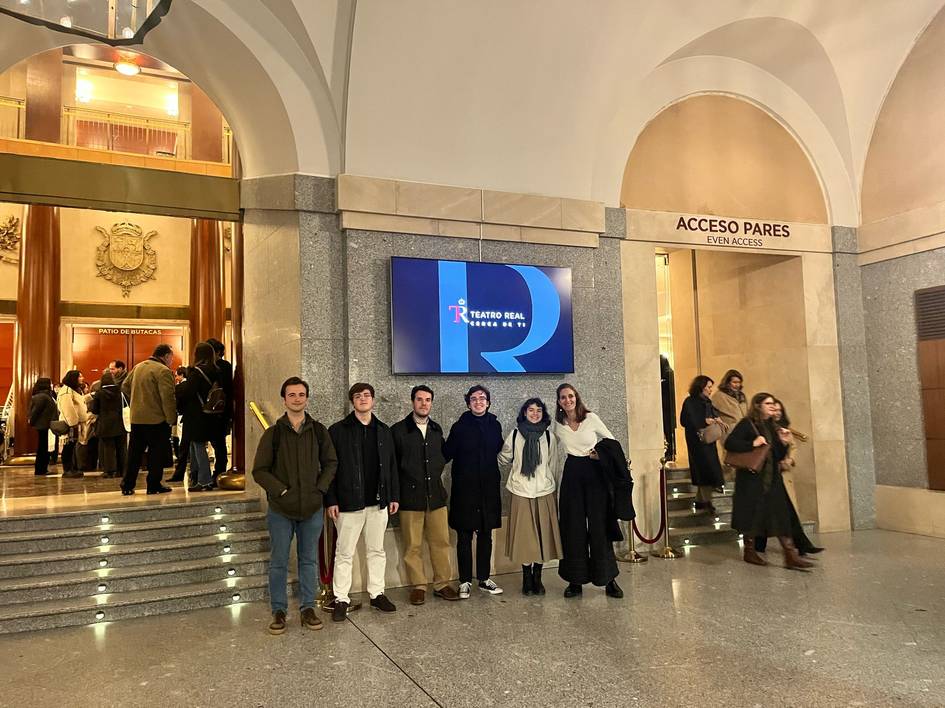 Un grupo de jóvenes posa frente a un edificio con un cartel que dice Teatro Real.