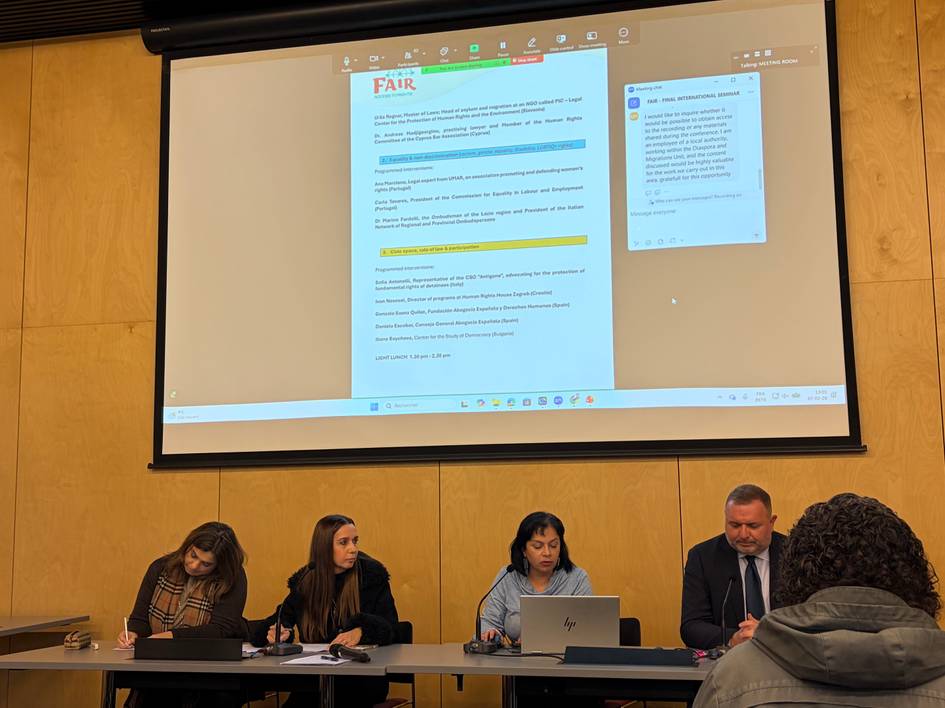 Reunión de varias personas discutiendo en una sala con una presentación en pantalla.