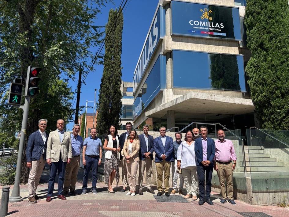 Un grupo de personas posa frente a un edificio con el letrero 'COMILLAS'.