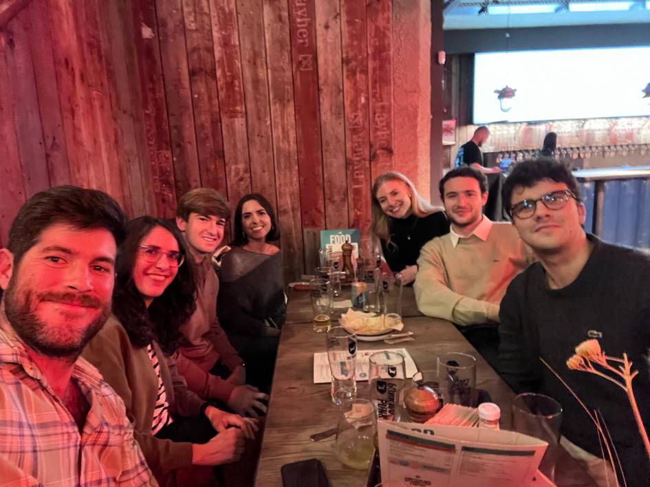 Un grupo de amigos sonríen mientras disfrutan de una cena juntos en un restaurante con ambiente acogedor.
