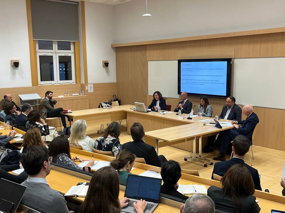 Un grupo de personas participa en una conferencia en una sala de clase.