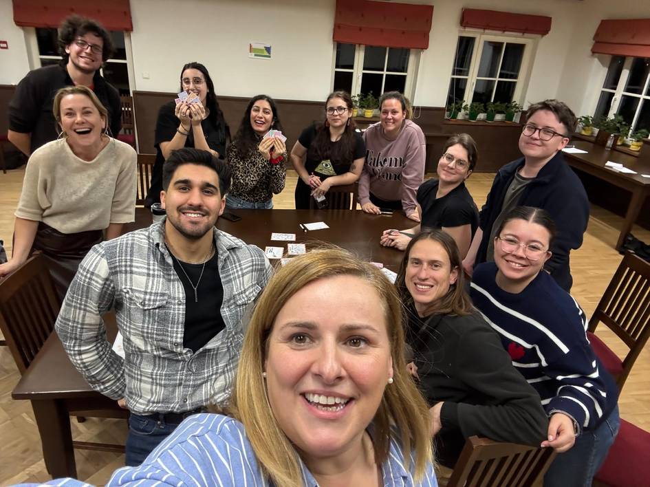 Un grupo de amigos sonríen en una reunión social mientras juegan en una mesa.