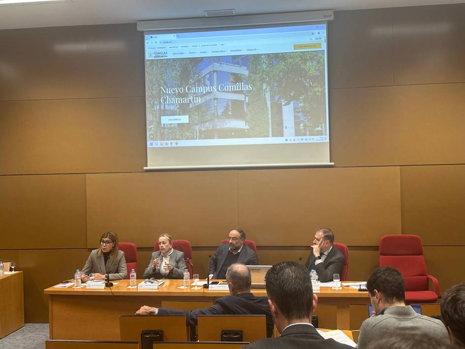 Una mesa redonda con varios ponentes discutiendo frente a una pantalla con información sobre 'Nuevo Campus Cantillas Chamartín'.
