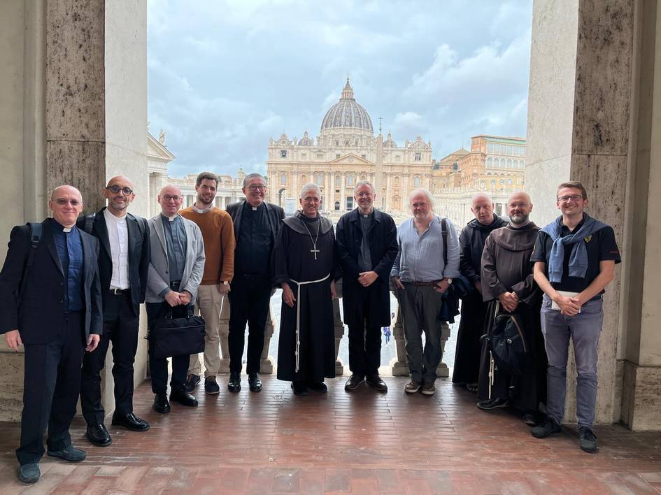 A group of men standing in front of St. Peter's Basilica in Vatican City.