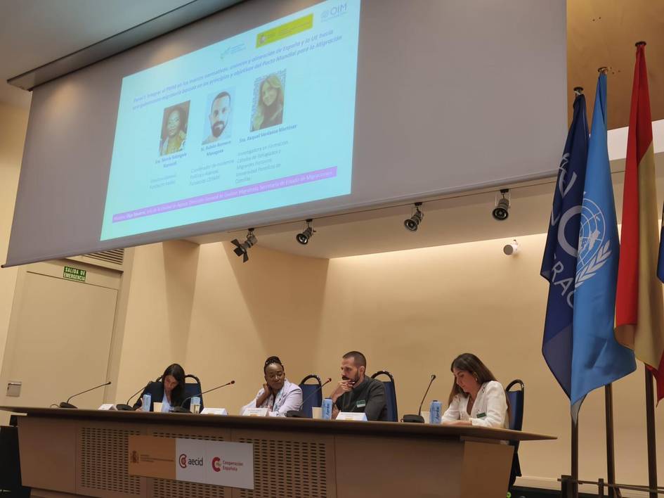Una mesa redonda con cuatro ponentes discutiendo en un auditorio.