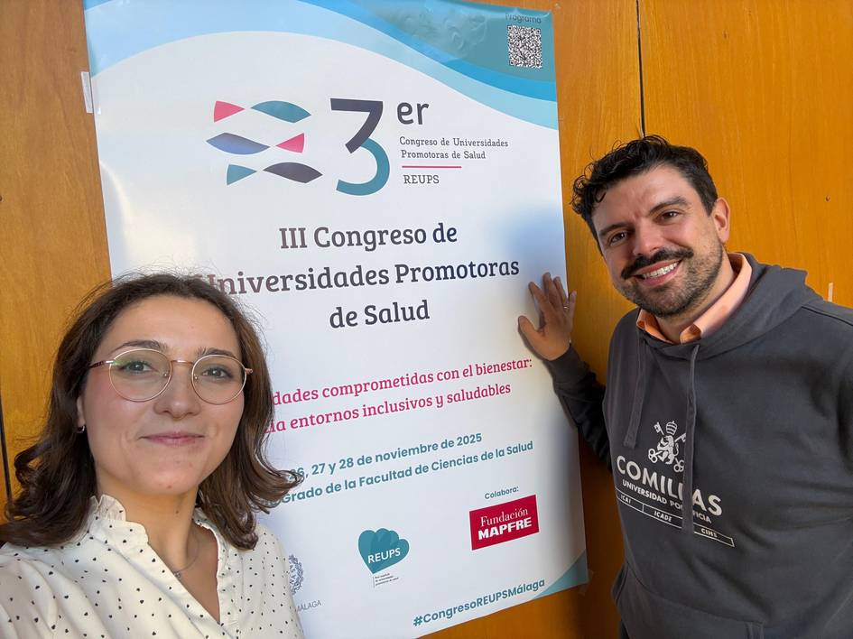 Dos personas posan junto a un cartel del III Congreso de Universidades Promotoras de Salud.