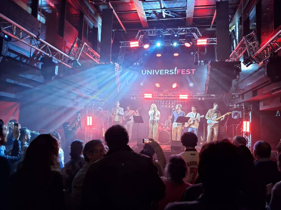 Una banda toca en un escenario iluminado durante un festival de música.